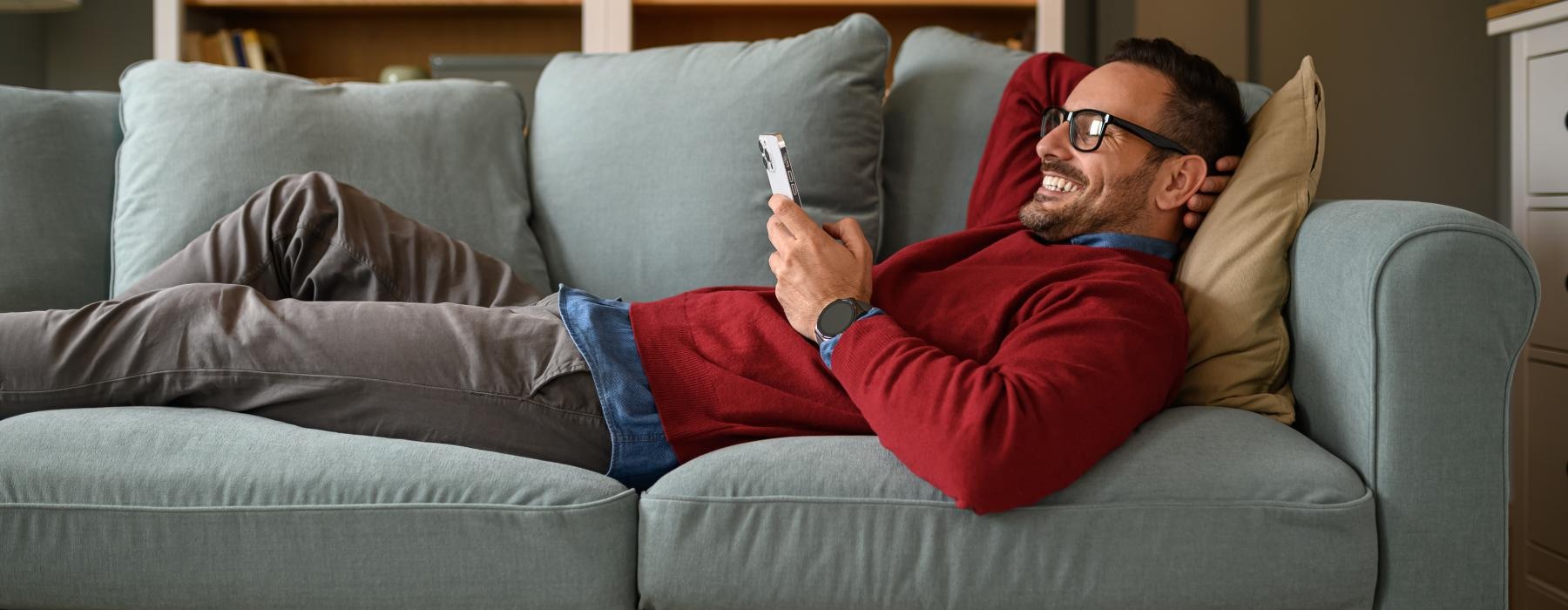 a person sitting on a couch on their phone