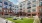 a courtyard with a bench and a building with a large lawn