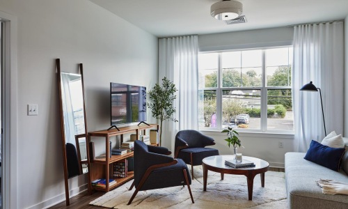 a living room with a couch, chairs and a tv